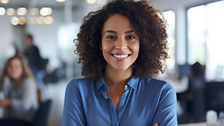Woman in blue shirt smiling at office