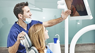 Dentist and patient looking at images on computer