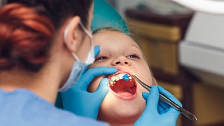 Fluoride being applied to little girl’s teeth