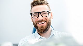 patient smiling after getting dental crown in The Colony