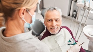 : a dentures candidate smiling at the dentist in The Colony
