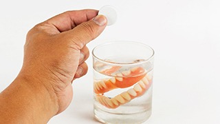 Dentures soaking in a solution