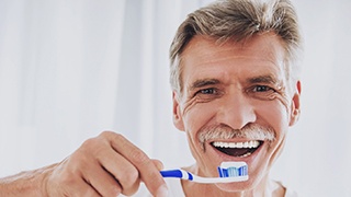 Man holding a toothbrush and toothpaste