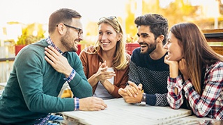 a man with dentures happily talking with friends