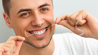 closeup of man flossing his teeth 