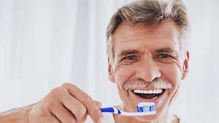 man brushing his teeth to prevent dental emergencies in The Colony