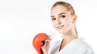 woman wearing a mouthguard to prevent dental emergencies in The Colony