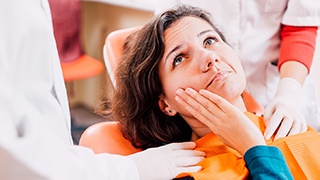 Pained woman visiting her The Colony emergency dentist 