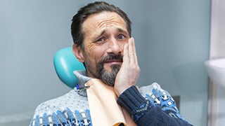 Man with toothache in the Colony visiting his emergency dentist