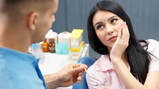 Woman holding cheek in pain