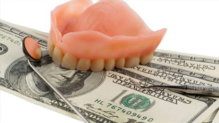 dollars bills in between a set of dentures 