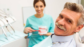 elderly man talking to his dental hygienist