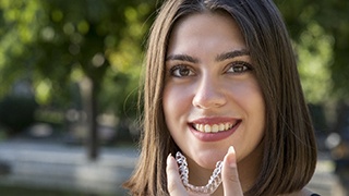 person holding their aligners while undergoing Invisalign in The Colony