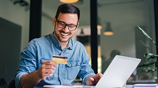 a person inputting their credit card information into a computer