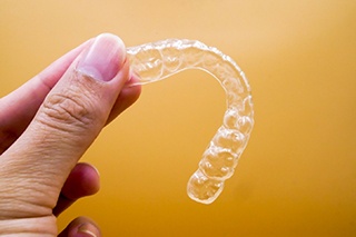 Closeup of woman holding Invisalign in The Colony