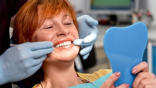 pleased lady checking smile using mirror