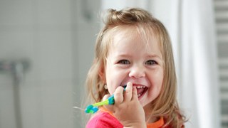 little girl brushing her teeth