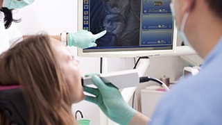 Dentist and patient looking at intraoral photos