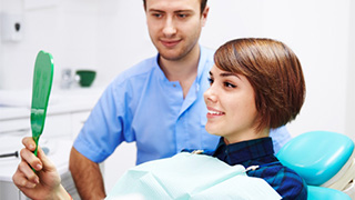 woman looking in dental mirror