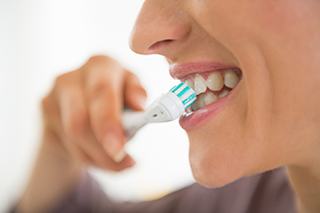 closeup of person brushing teeth after teeth whitening in The Colony