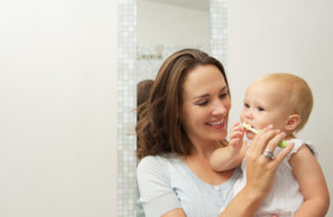 Mother brushing child's teeth