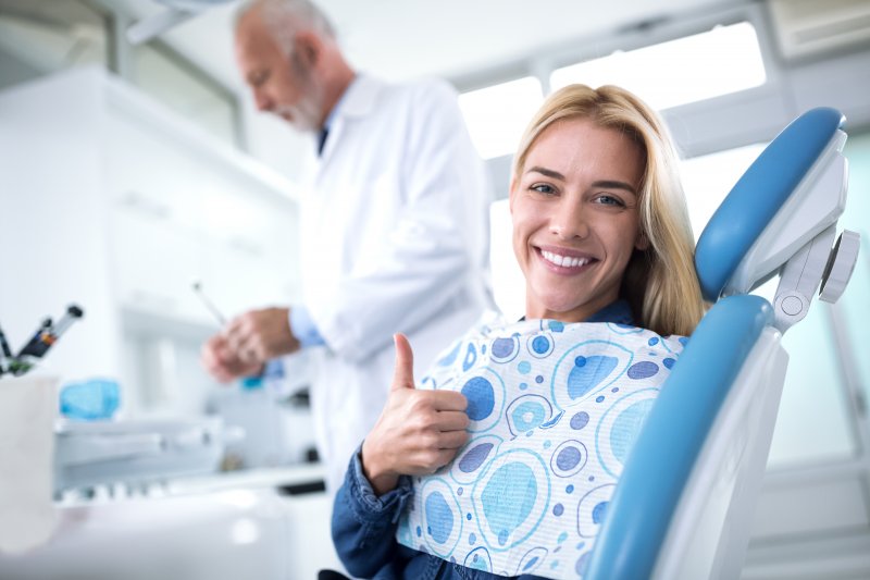 Patient giving thumbs up at routine dental appointment