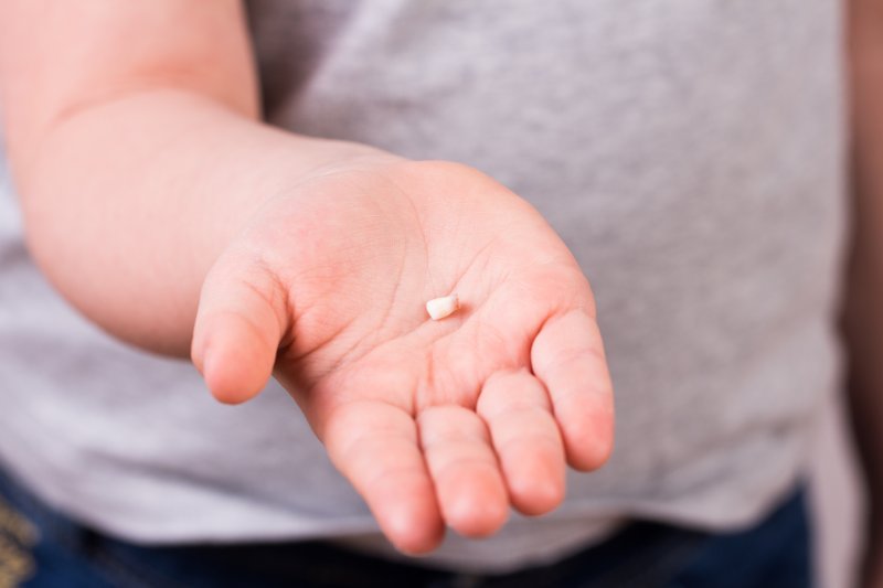 Person holding a knocked-out tooth