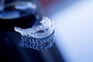 Set of clear aligners on a dark reflective surface