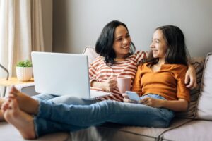 Teen relaxing with mom on the couch.