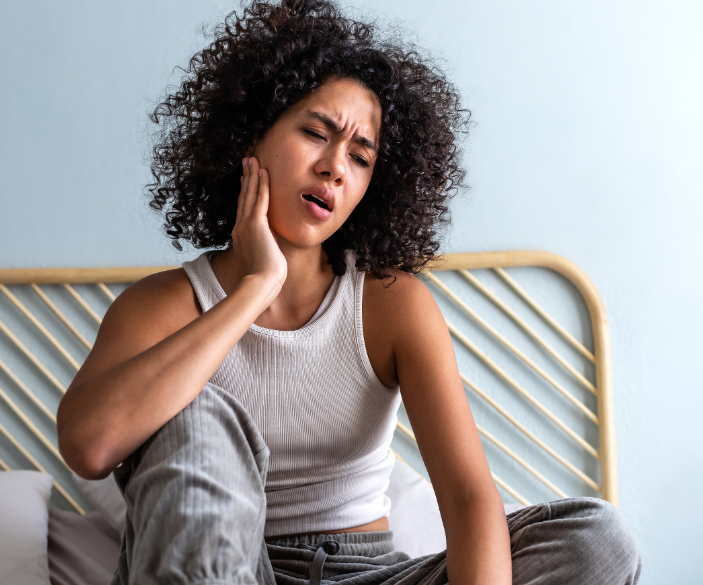 Woman holding jaw, in pain